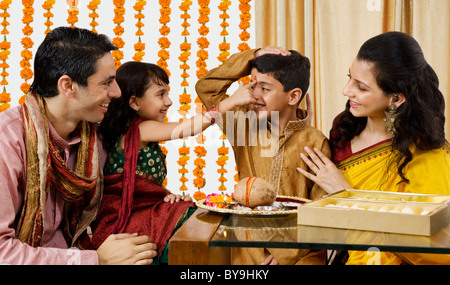 Girl putting a tikka on her brothers forehead Stock Photo