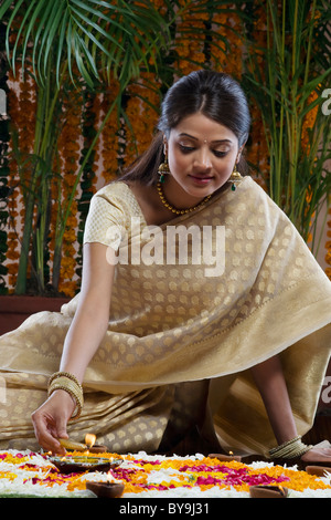 Woman lighting a diya Stock Photo