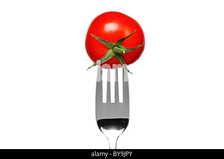 Photo of a tomato on a fork isolated on a white background, part of a series. Stock Photo