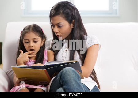 Mother and daughter reading a story book Stock Photo