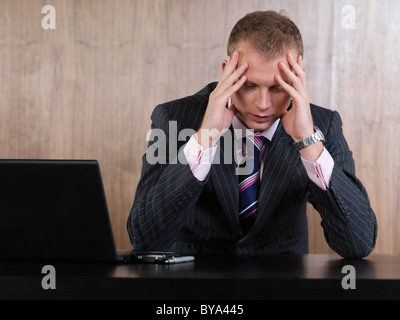 Business man head in hands in office Stock Photo