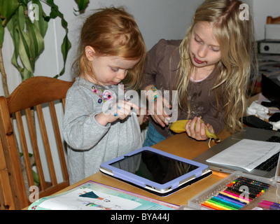 Sisters Playing with an iPad England Stock Photo