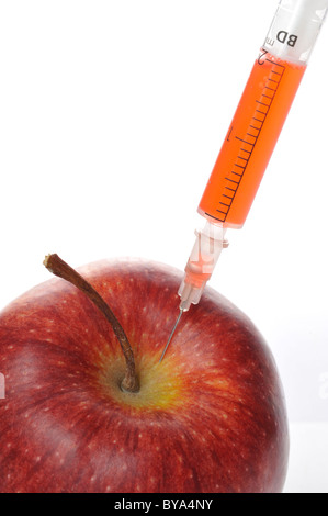 Syringe sticking in an apple, symbolic image for GM, genetically modified, food Stock Photo