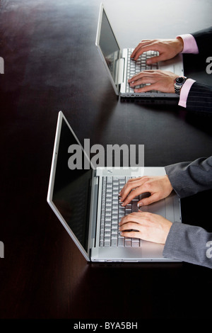 Business man and woman on computers Stock Photo