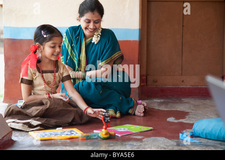 Little girl playing the traditional kid's game of bebeleche (hopscotch ...