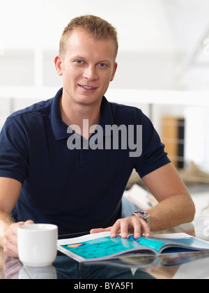 Man relaxing at home with hot drink Stock Photo