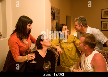 Group with wine glasses chatting over dinner table Stock Photo