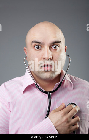 Man using a stethoscope to check his heart rate Stock Photo