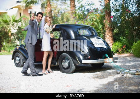 Bridal couple in front of car Stock Photo