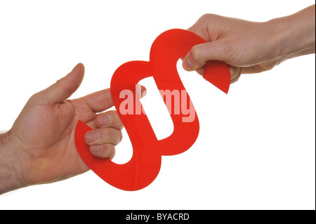 Man and woman, hands tugging at a legal citation symbol, symbolic image for litigation, divorce battle Stock Photo