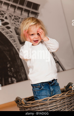 Girls, 1.5 years, playing hide and seek Stock Photo