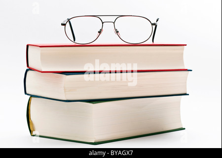 Reading glasses lying on a pile of books Stock Photo