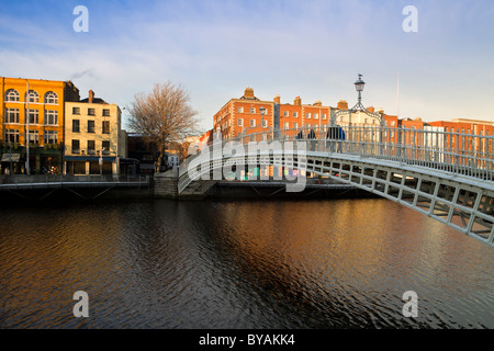 Dublin landmark - Ha'penny bridge on Liffey River. Rows of colorful houses. Stock Photo