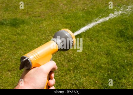 Hand holding a Hozelock water gun Stock Photo