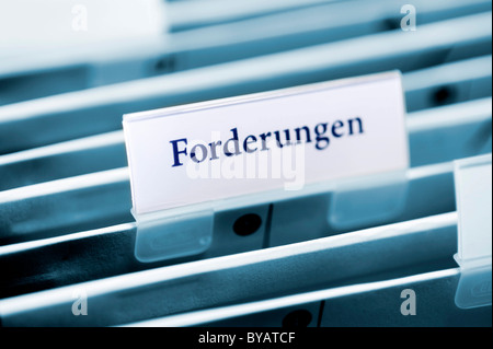 Rider on a hanging folder labeled Forderungen or claims Stock Photo