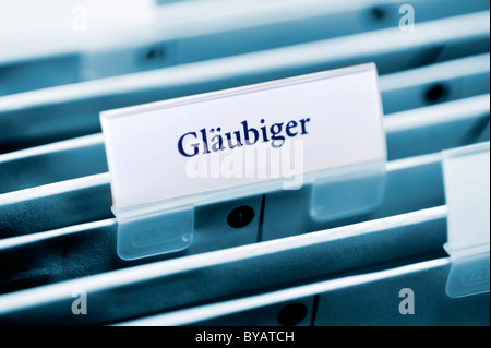 Rider on a hanging folder labeled Glaeubiger or creditors Stock Photo