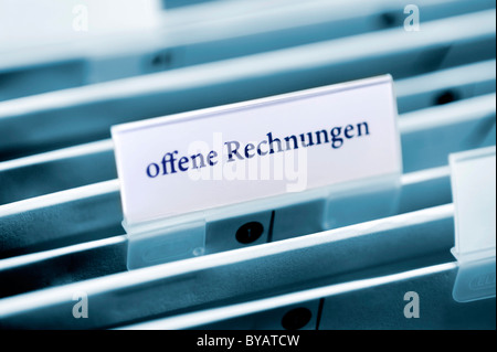 Rider on a hanging folder labeled offene Rechnungen or unpaid bills Stock Photo