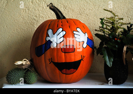Pumpkin with a face painted on, keeping its eyes shut Stock Photo