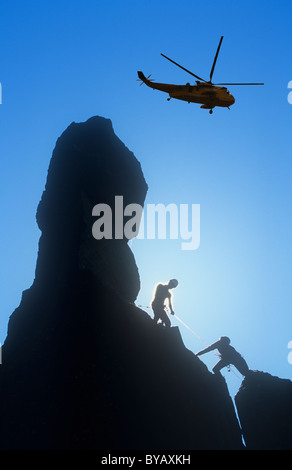 Climbers on Napes Needle, a pinnacle of rock on Great Gable in the Lake district, UK, with a helicopter. Stock Photo