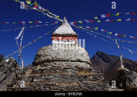 A stupa with prayer flags and Mani stones in Mongla, Khumbu, Sagarmatha National Park, Nepal, Asia Stock Photo