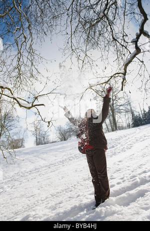Woman throwing snow into the air, Landshut, Lower Bavaria, Bavaria, Germany, Europe Stock Photo