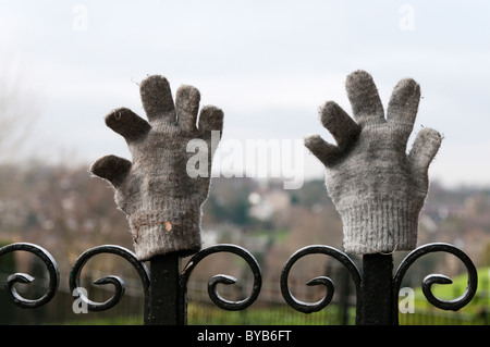 A pair of lost gloves placed on park railings. Stock Photo