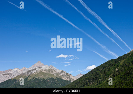 Mountain landscape with vapour trails from aircraft in the blue sky, Zuoz, Graubuenden or Grisons, Switzerland, Europe Stock Photo