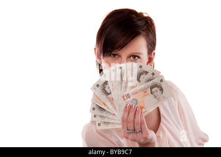 Brunette woman holding ten pound notes in her hands Stock Photo