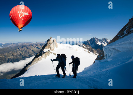 Climbers on the 4000 metre peak of Mont Blanc Du Tacul above Chamonix France, with a hot air balloon. Stock Photo