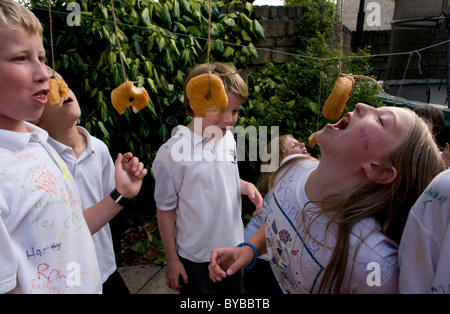 Children eating doughnuts off a string Stock Photo