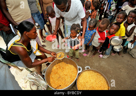 Food distribution to needy children at a camp for victims of the January 2010 earthquake, Croix-des-Bouquets district, , Haiti Stock Photo