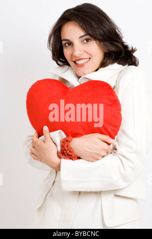 Woman holding a heart-shaped cushion Stock Photo