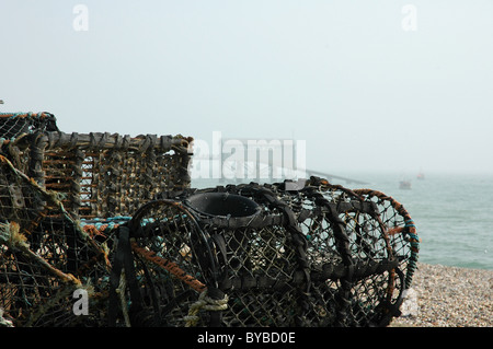 Fishermen's pots on a bright misty morning at Selsey. Lifeboat House behind. Stock Photo