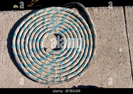 Coiled rope on quayside Stock Photo