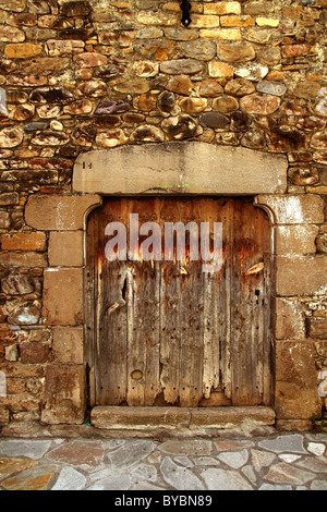 Aged wood door in medieval masonry Pyrenees house facade Stock Photo