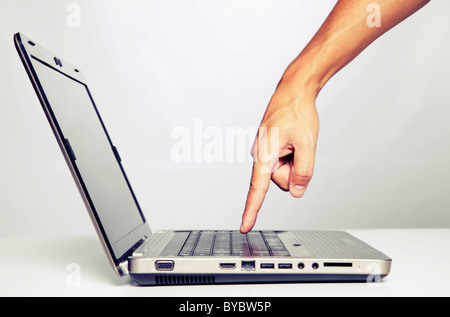 hand gesture next to a laptop with cross processing effect (selective focus) Stock Photo