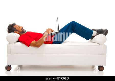 Relaxing man using laptop and lying on the sofa Stock Photo
