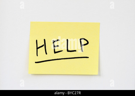 help written in black ink on a small yellow sticky note stuck on a white wall Stock Photo