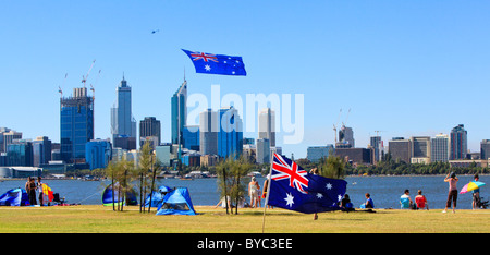 People celebrating Australia Day at Sir James Mitchell Park as a helicopter pulls a huge Australian Flag over the city. Stock Photo
