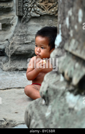 Cambodian baby in ruins of Angkor Wat Stock Photo