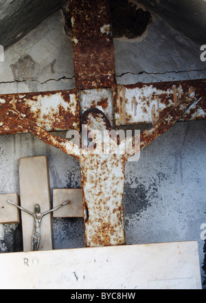 Rusty cross on small shrine on beach in Spain Stock Photo