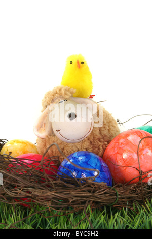 Easter basket with Easter eggs, sheep and chicks on a green meadow Stock Photo