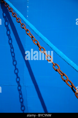Metal chain and nylon blue rope side by side ( ship mooring ropes )