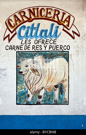 delightful hand painted street art sign painting on wall of Mexican butcher shop depicting a cow advertising beef & pork for sale Mexico Stock Photo