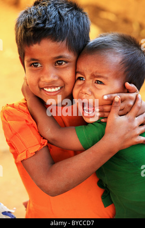 Boy crying in his sister's arms Andhra Pradesh South India Stock Photo