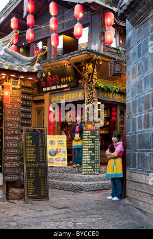 Waitresses touting for customers outside restaurant in Lijiang old town, Yunnan Province, China. JMH4758 Stock Photo