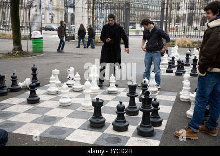 People playing a game of oversized / large / giant / big chess in a public park in Geneva / Geneve, Switzerland. Stock Photo