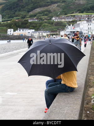 Under a black golf umbrella in Ireland Stock Photo