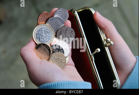 Child's hand with a red purse and British money Stock Photo