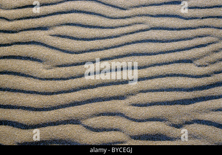 Patterned waves in white sand in the evening. Stock Photo